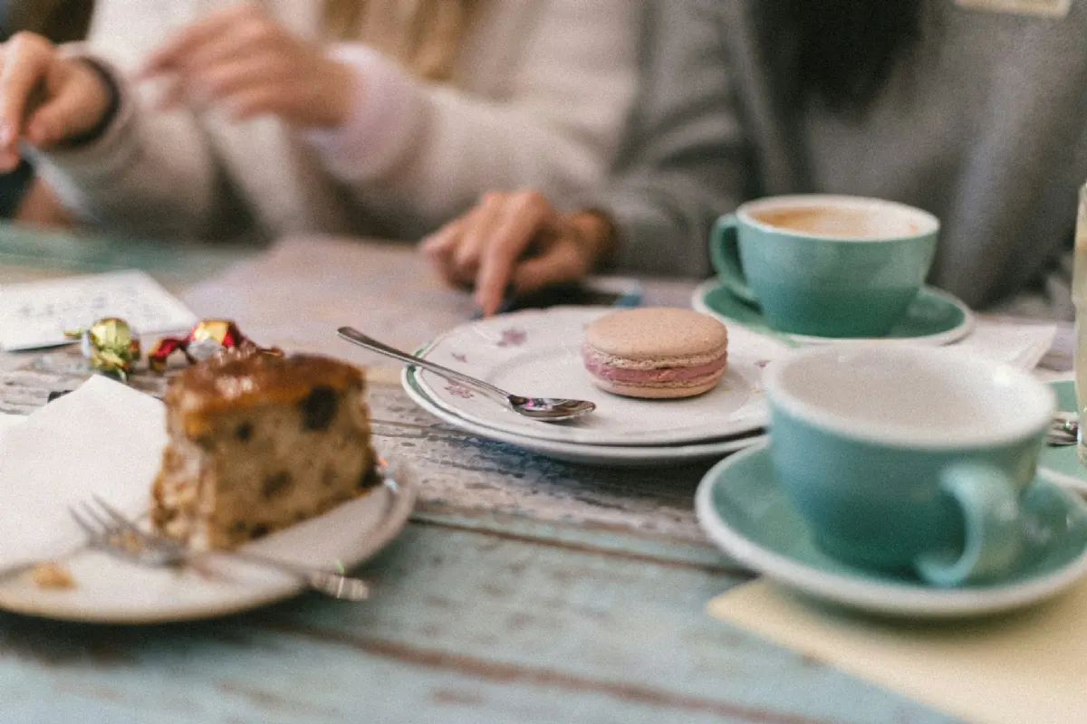 Clientes disfrutando de un café y una tarta