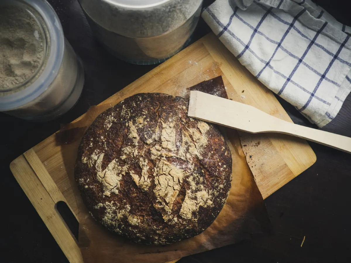 Panadero moldeando una hogaza de pan en una mesa de madera